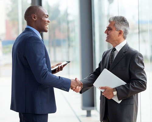 Image: Handshake implying a business deal closure. Investing in cybersecurity boosts business, turning expenses into revenue generators.