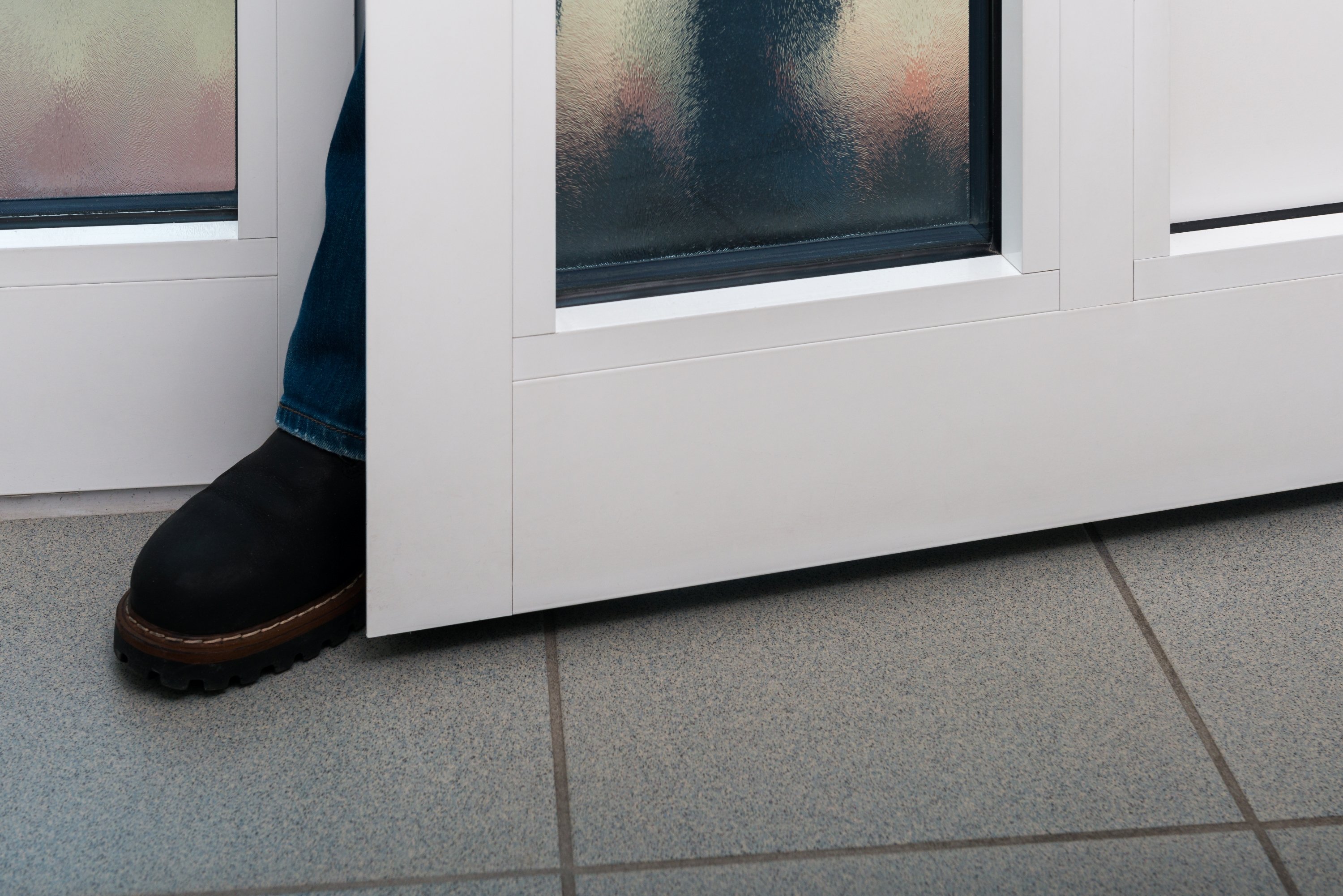 Image: Person wedging foot in closing door. Illustrates providers' extreme tactics for business gains, concealing post-contract surprises.